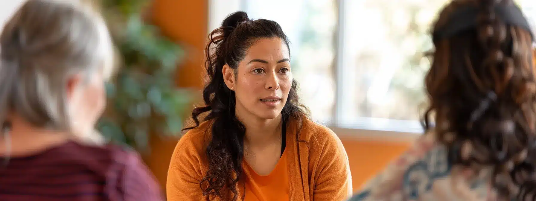 a therapist speaking with members of the local community to identify their needs and demographics for tailored mental health services.