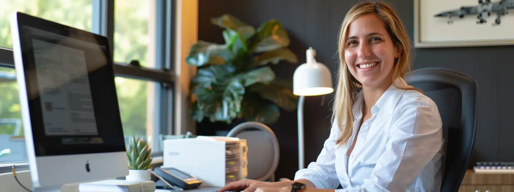 a smiling therapist sitting at their desk, reading glowing client reviews on a computer screen.